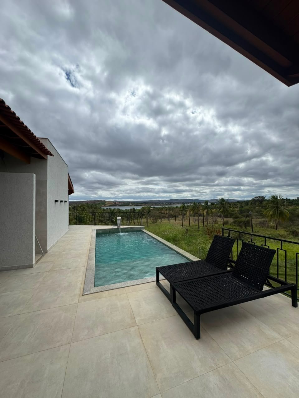 Piscina com espreguiçadeiras e vista aberta